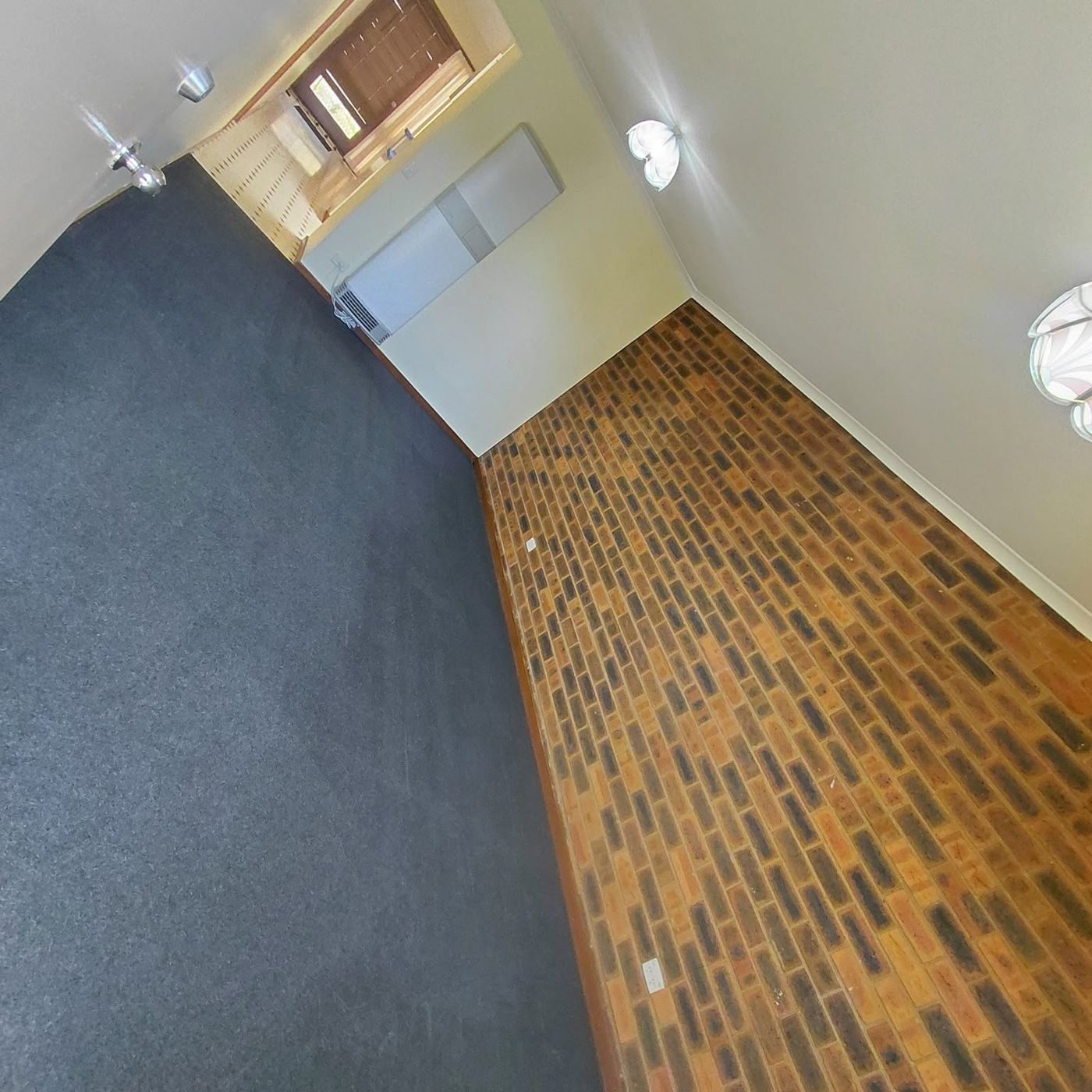 Dark blue carpet cleaned in a rental with a brick feature wall